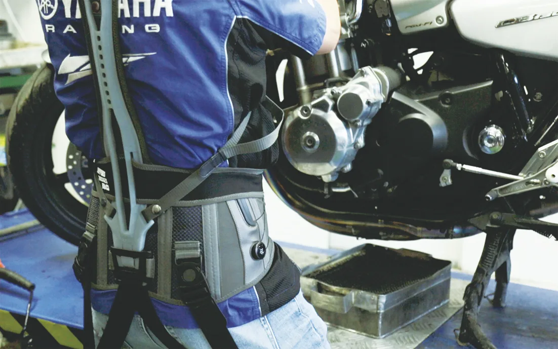 Trabajador industrial utilizando un exoesqueleto ocupacional en un entorno de taller